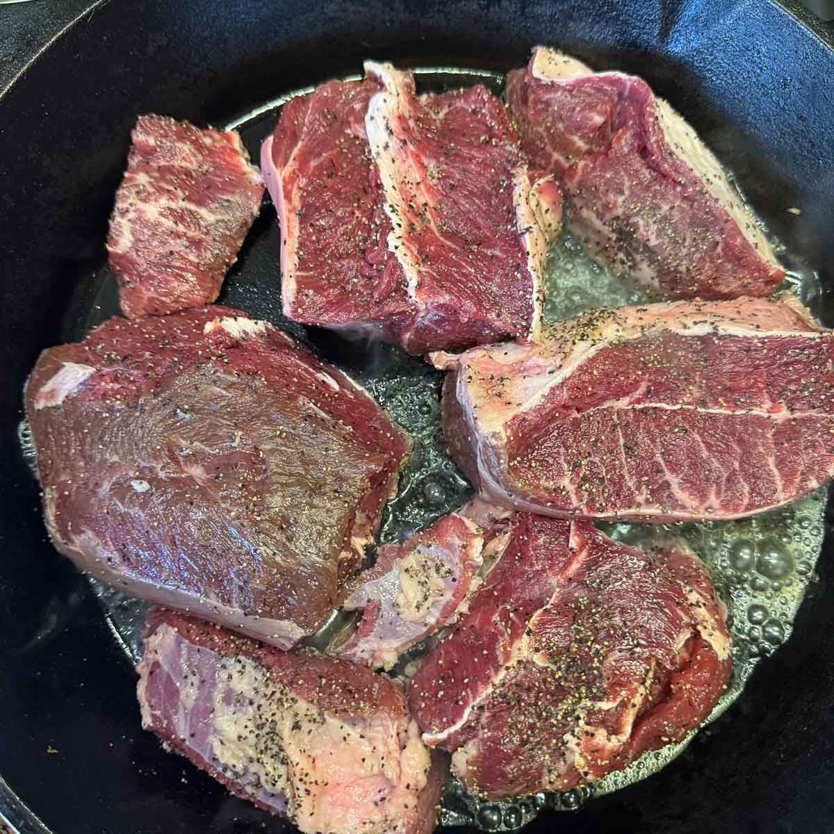 chuck roast chunks in a pan