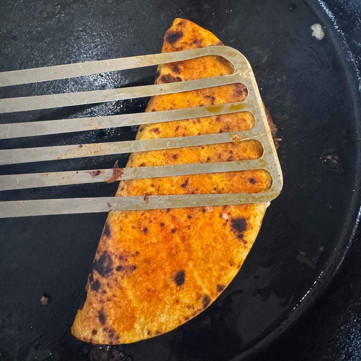 searing birria tacos in a pan