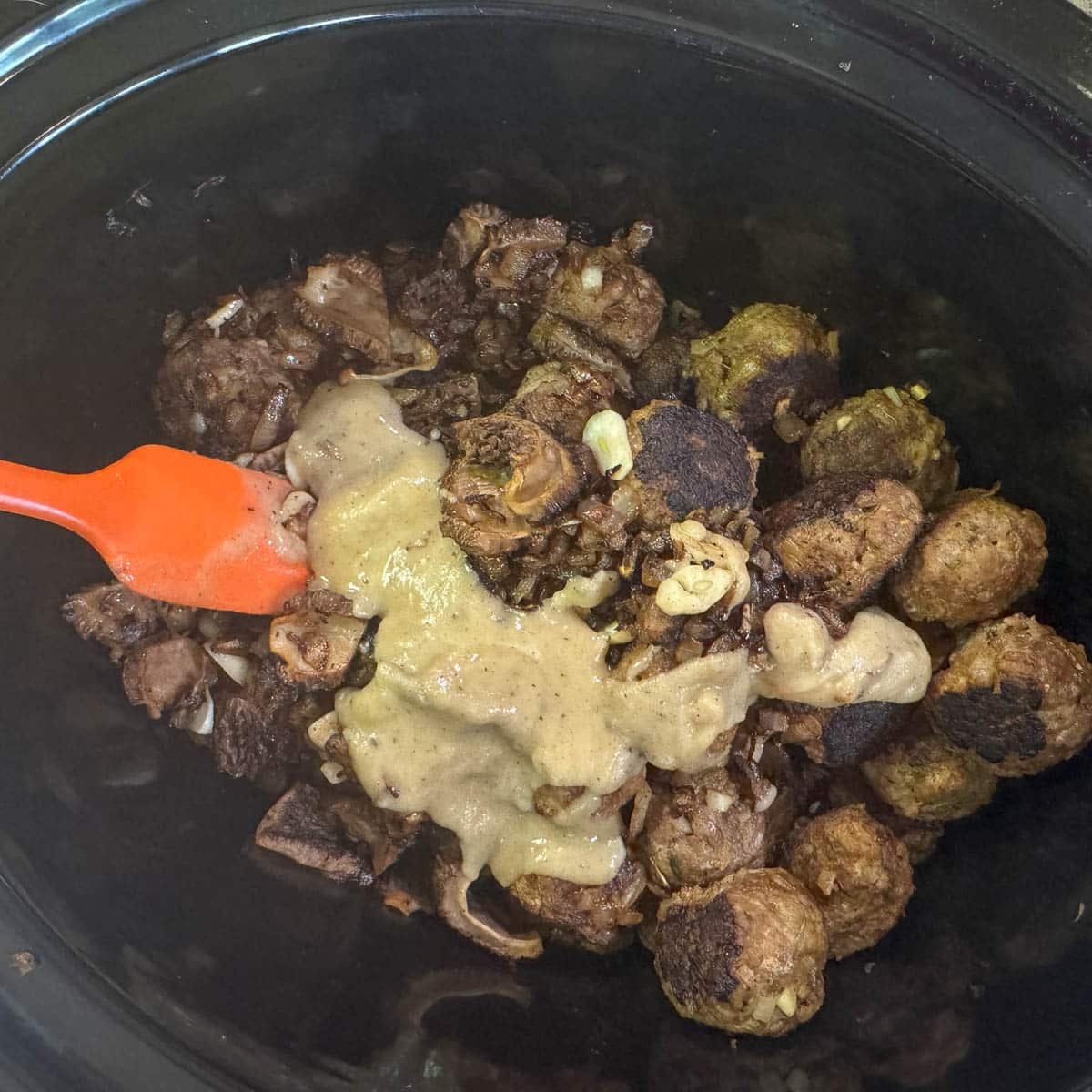 meatballs covered with roux in a slow cooker
