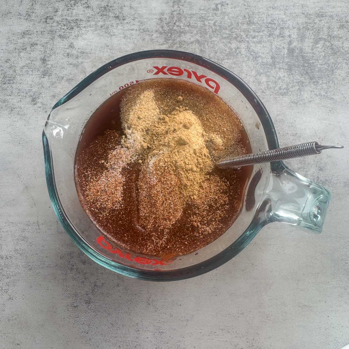 cooking liquid and spices in a measuring cup before being whisked