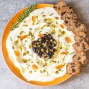 Whipped goat cheese dip with rosemary sprig and crackers.