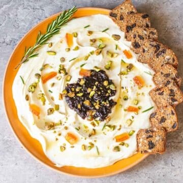 Whipped goat cheese dip with rosemary sprig and crackers.