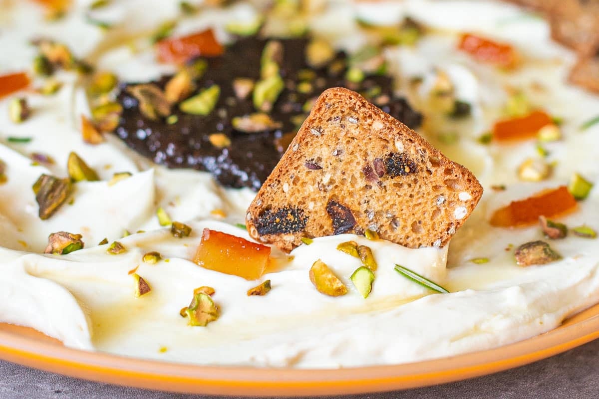 cracker dipped in whipped goat cheese dip.