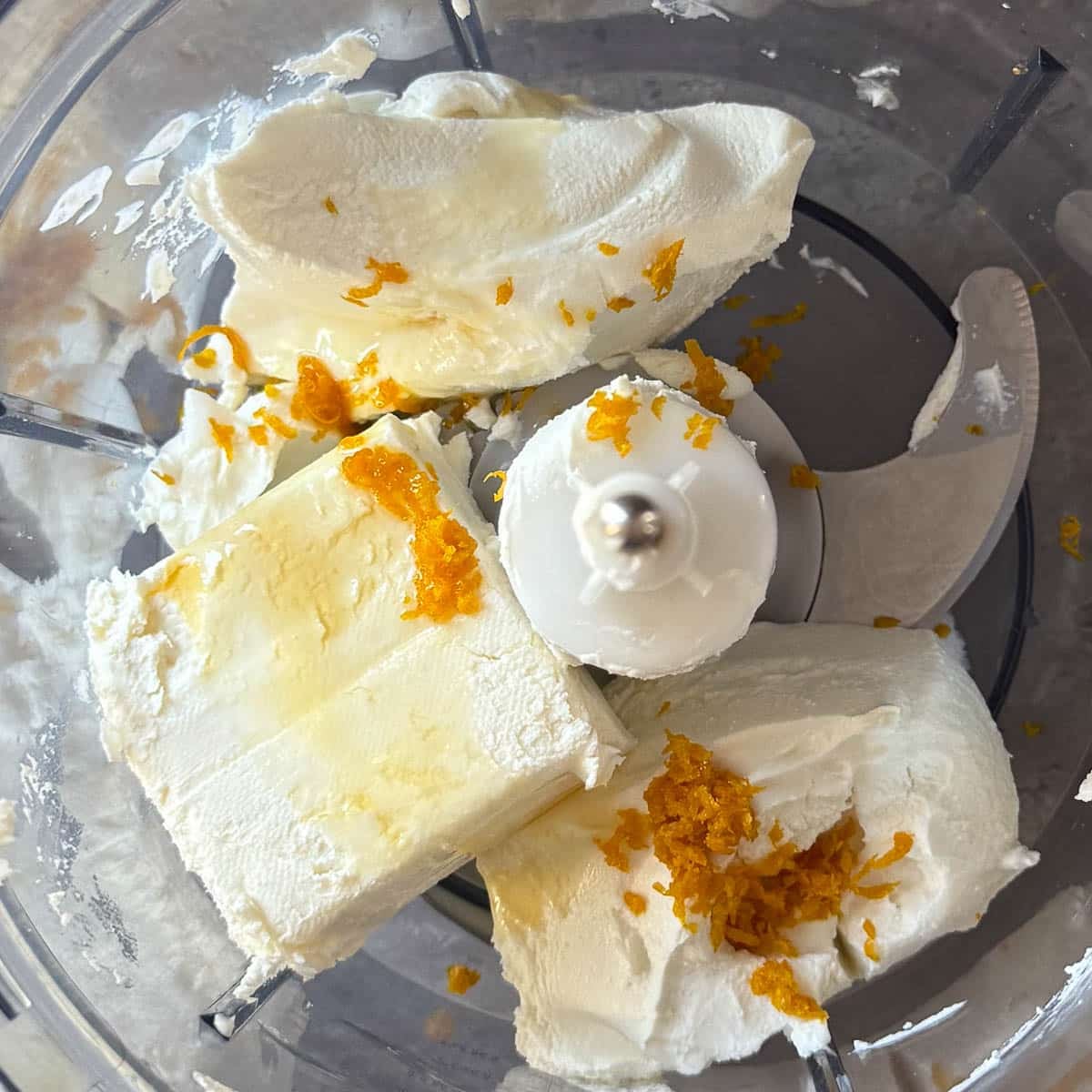 goat cheese, cream cheese, honey, and orange zest in food processor.