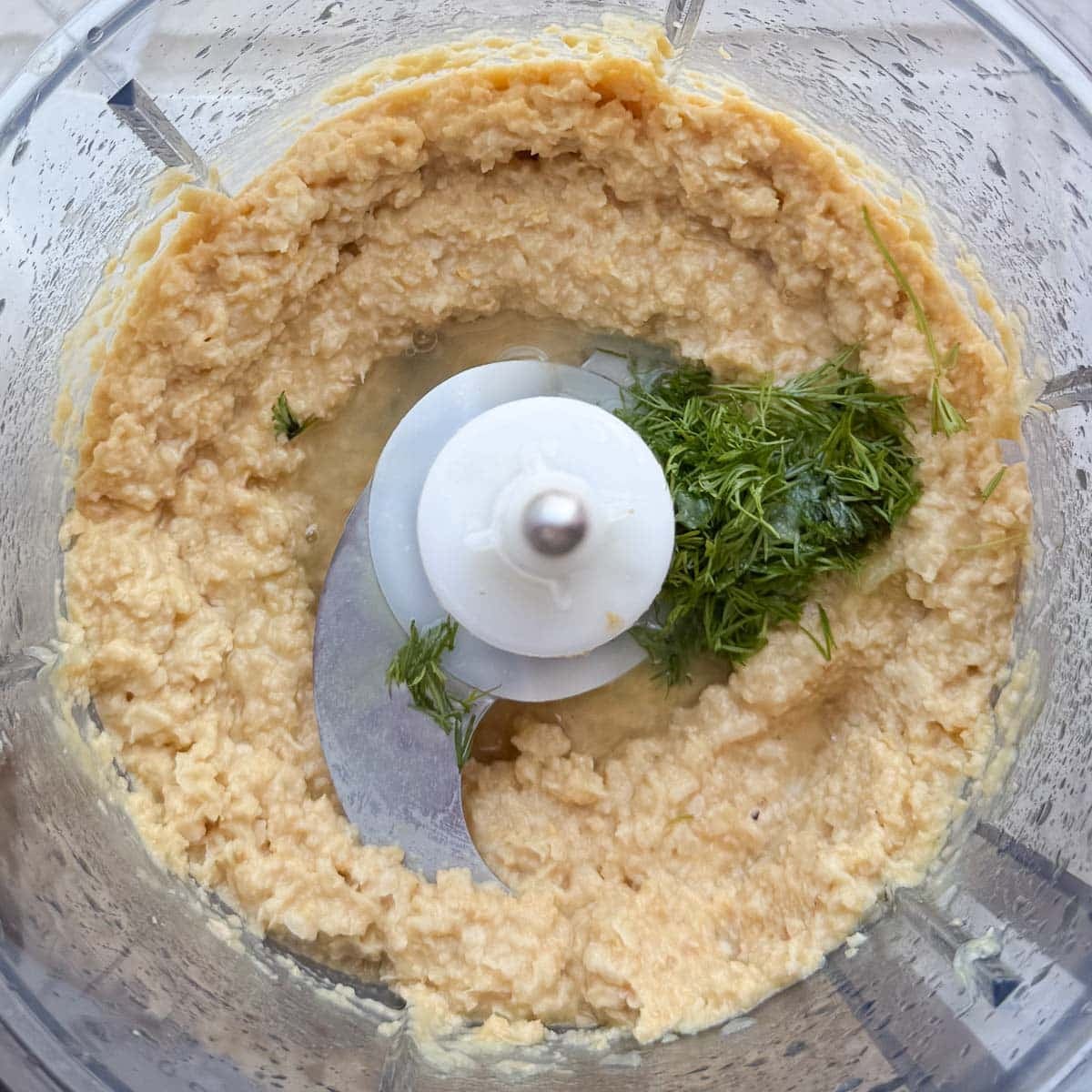 fresh dill, lemon juice, aquafaba added to food processor before blending.