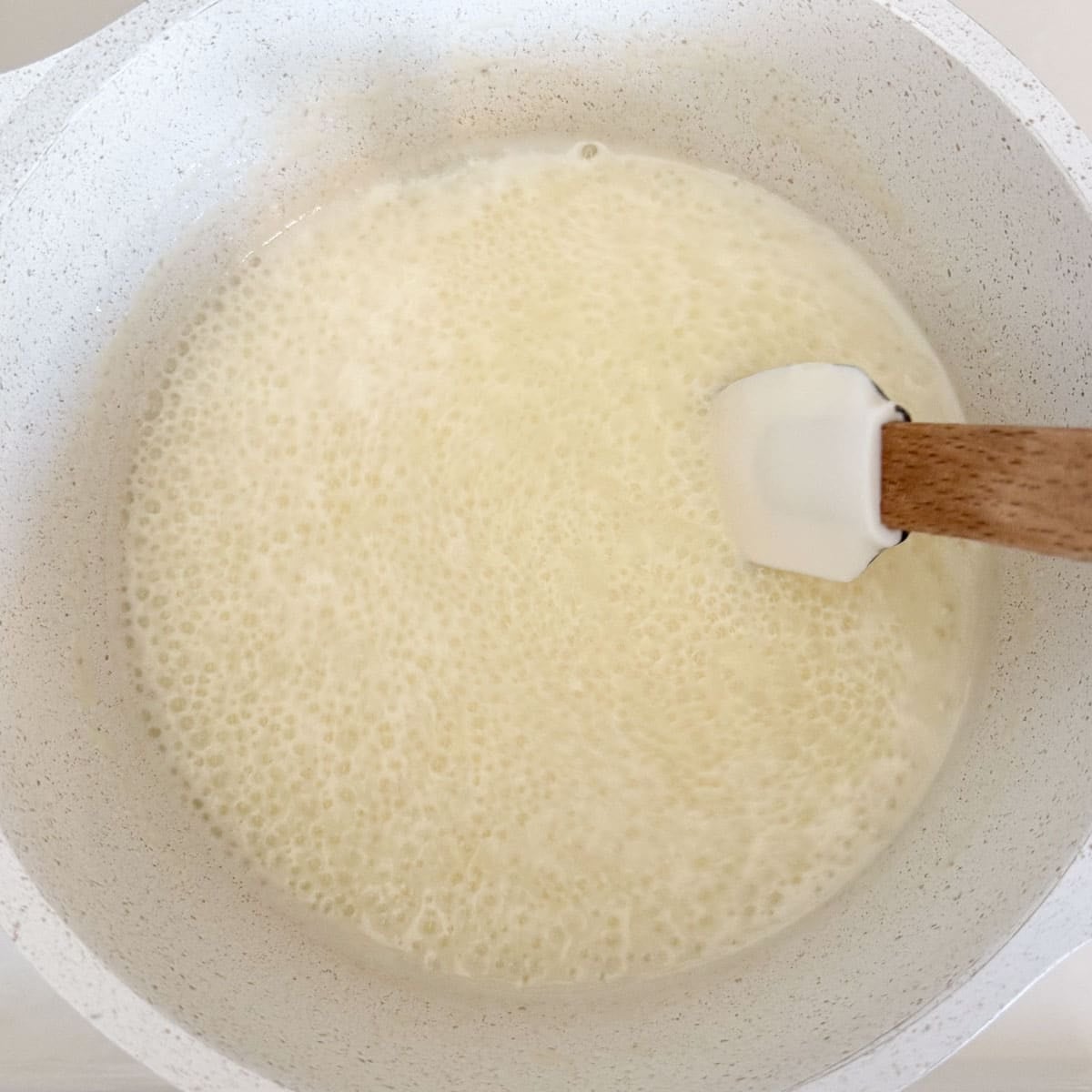 spatula stirring boiling cream.
