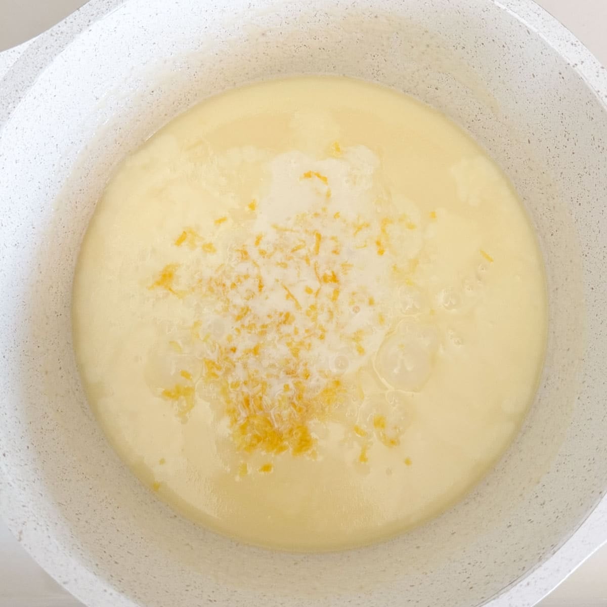 lemon juice, zest, and elderflower liqueur in pot before mixing.