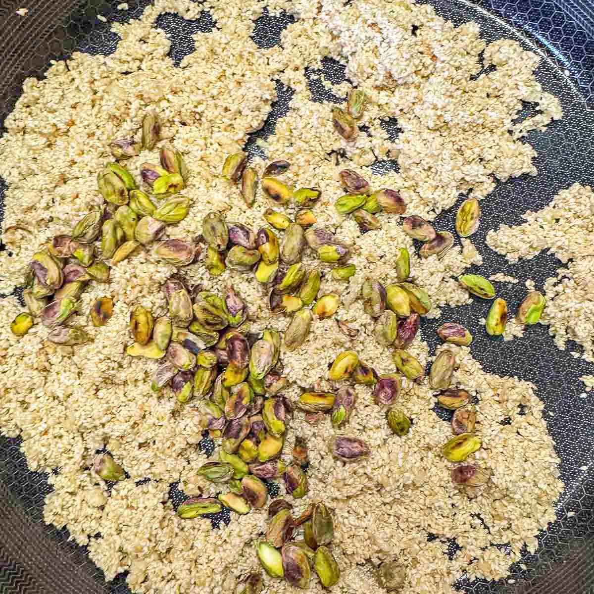 sesame seed mixture with toasted pistachios in a pan