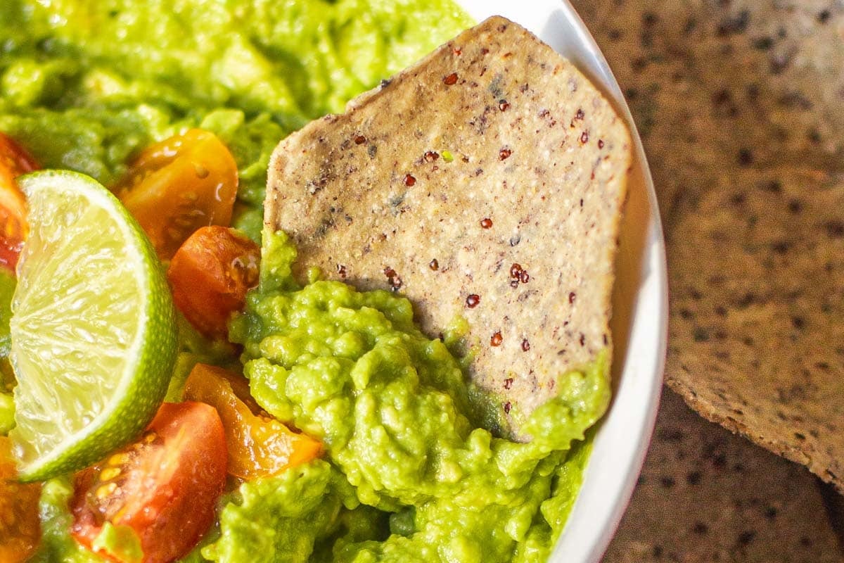 tortilla chip scooping 4 ingredient guacamole.