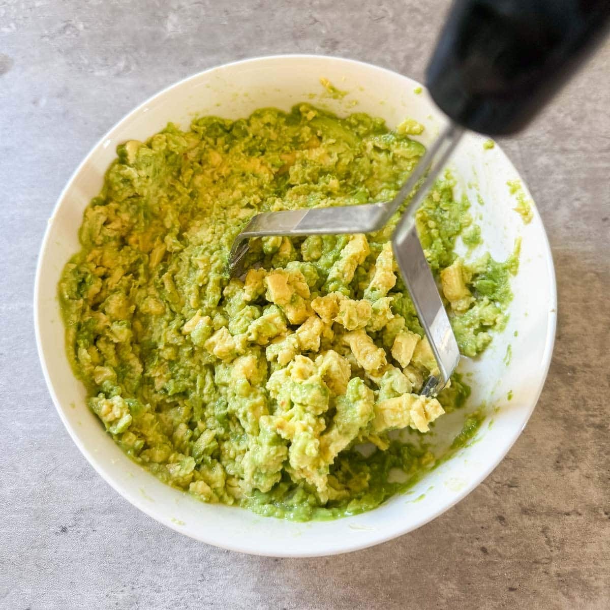 potato masher mashing avocados.