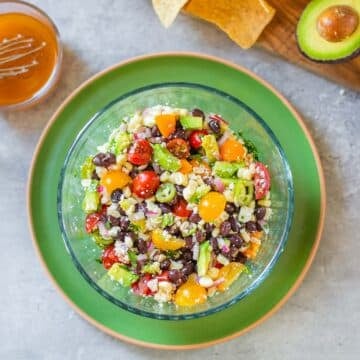 black bean and corn salsa beside vinaigrette, chips, avocado.