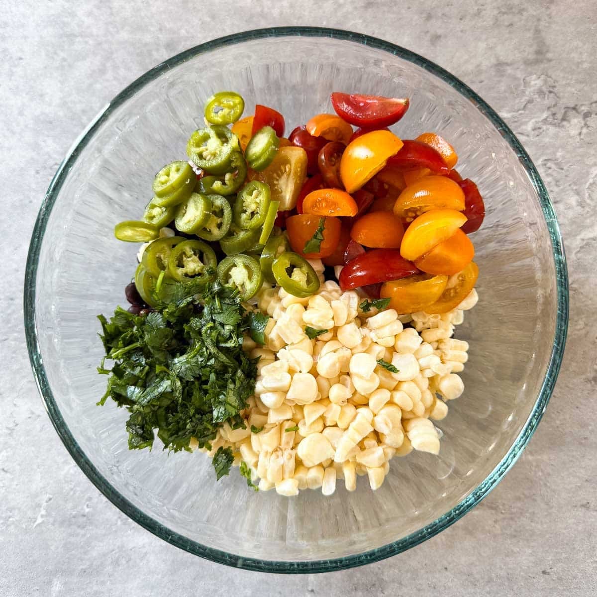 cilantro, serannos, and tomatoes added to corn and beans.