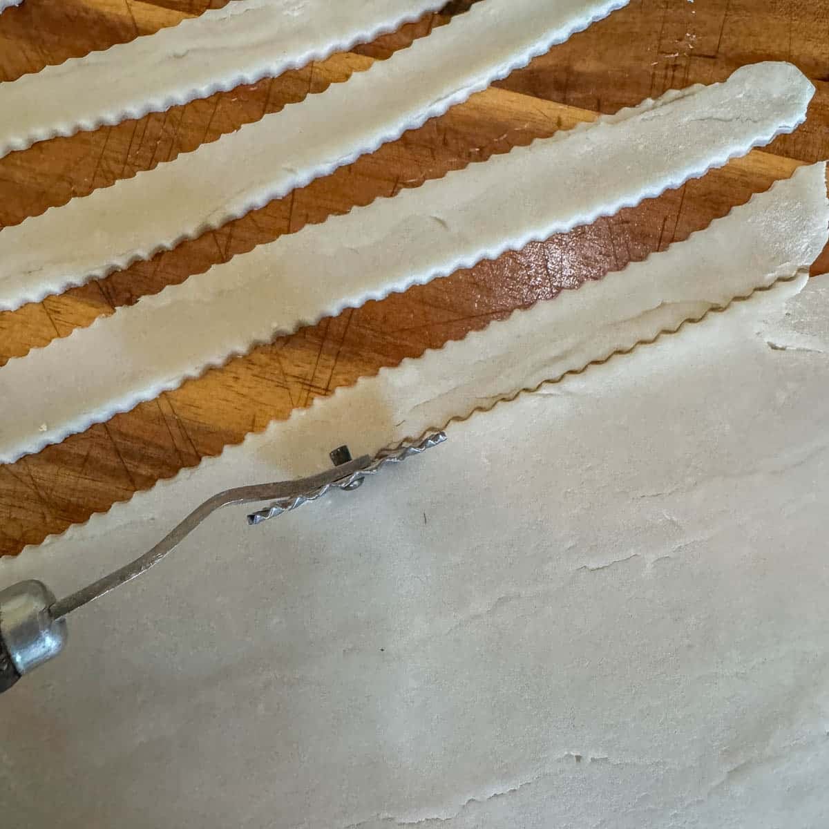 cutting strips of dough with pastry cutter
