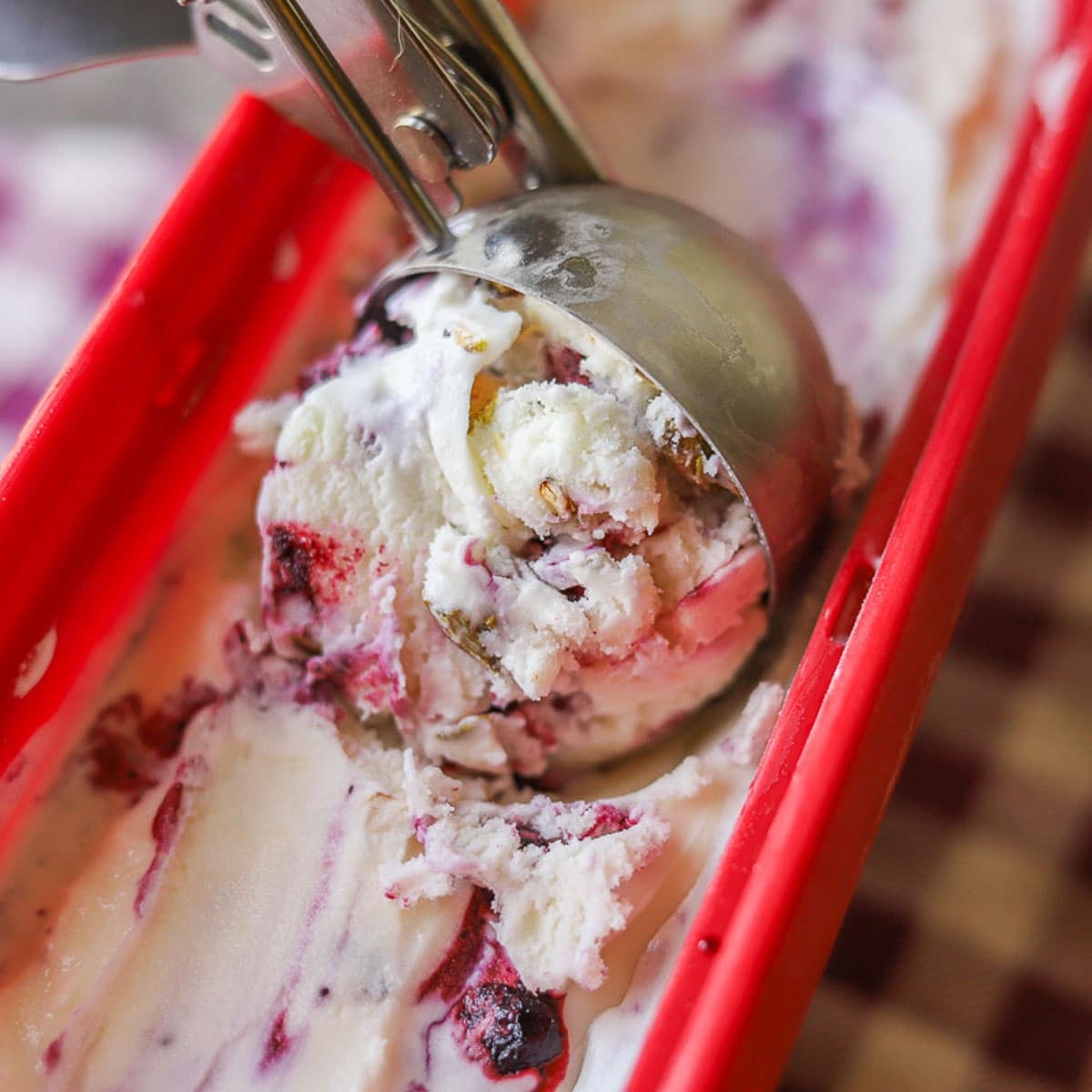 huckleberry ice cream being scooped from red tub