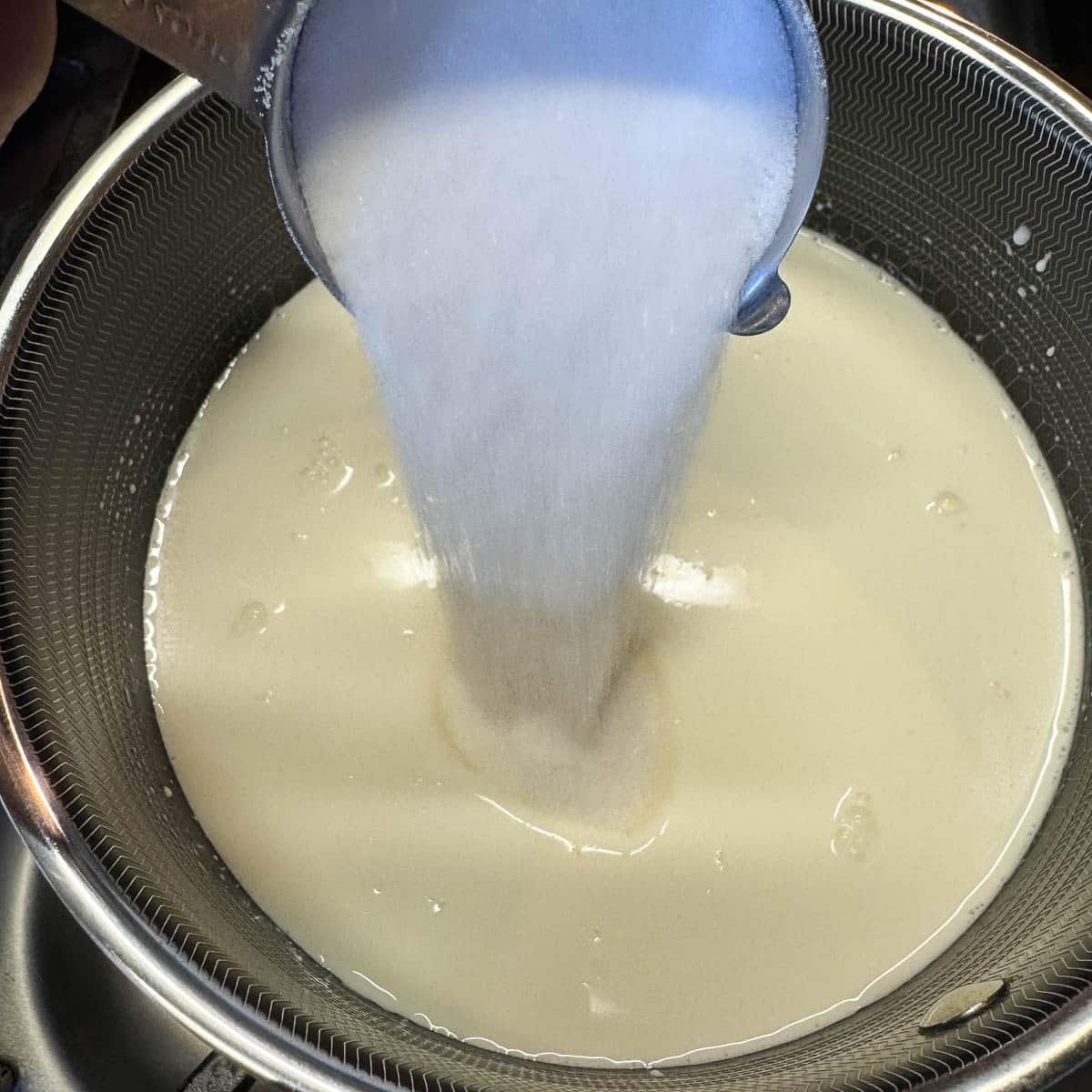 adding sugar to ice cream base