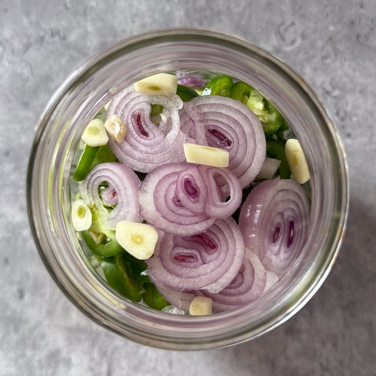 sliced serranos, garlic, and shallot in jar.