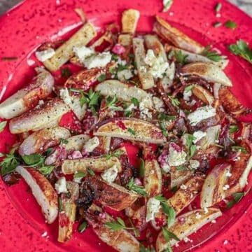 roasted turnips and onions on a red plate