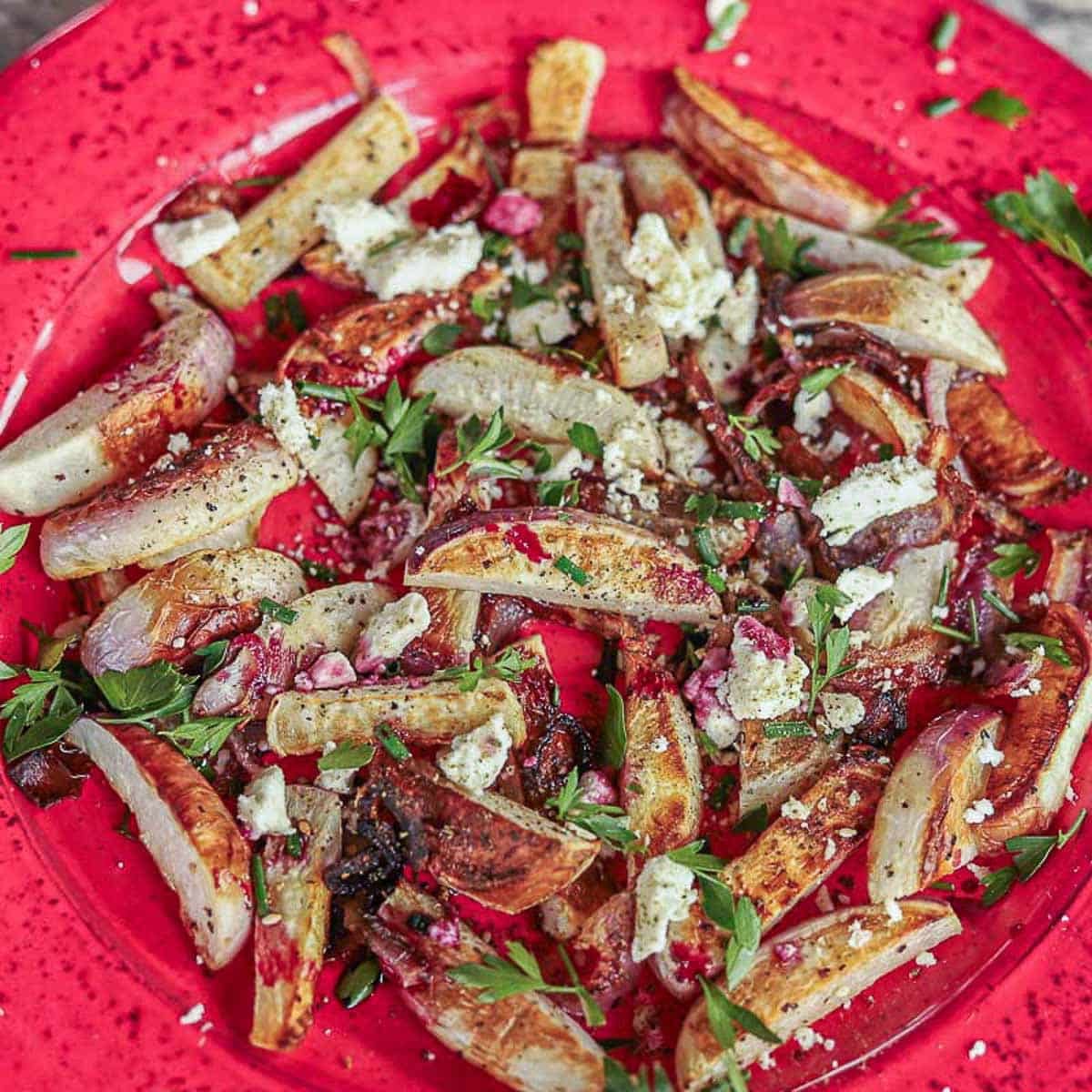 roasted turnips and onions on a red plate