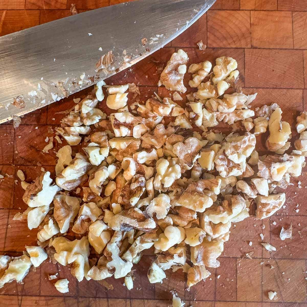chopped walnuts on a cutting board with a knife