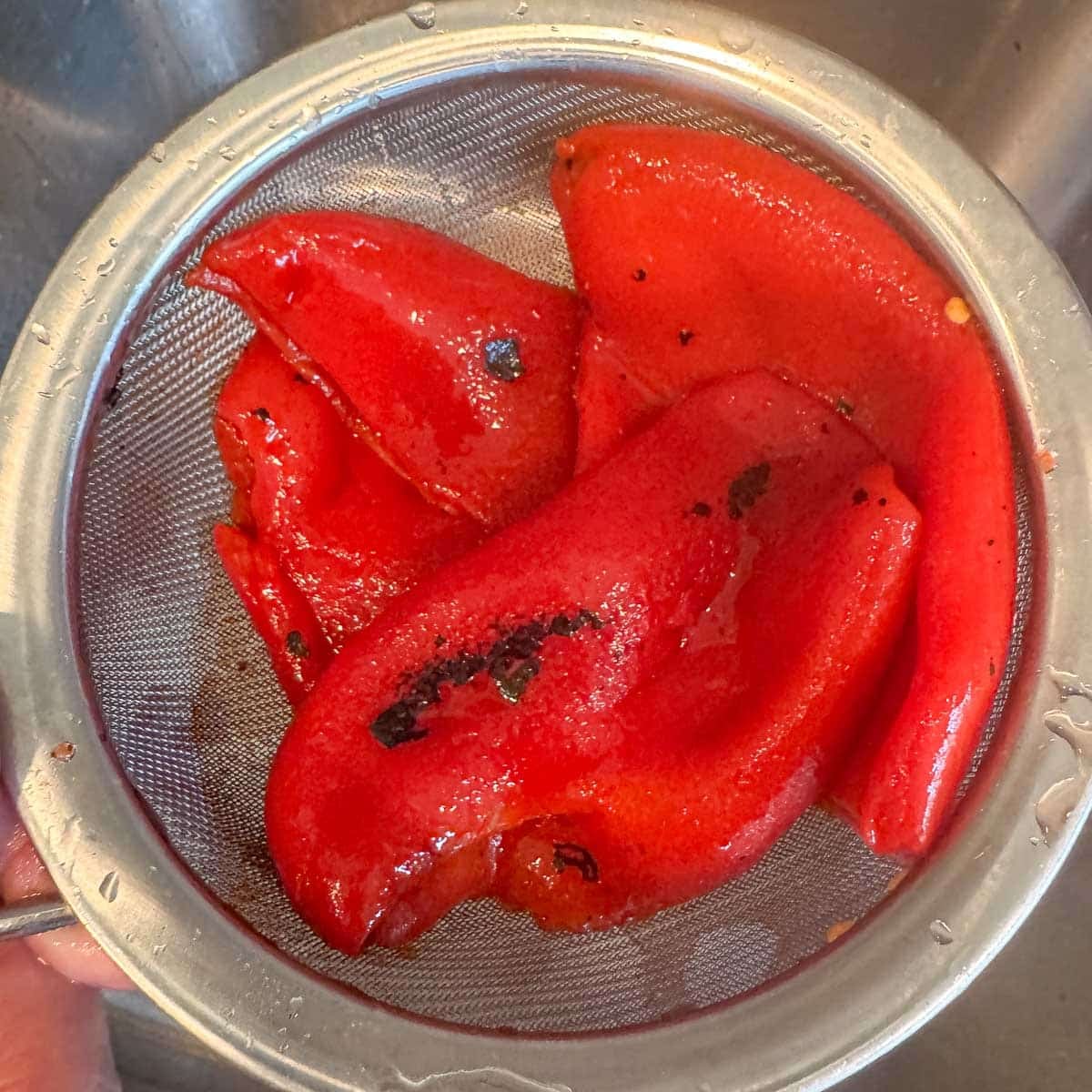 roasted red peppers draining in a strainer