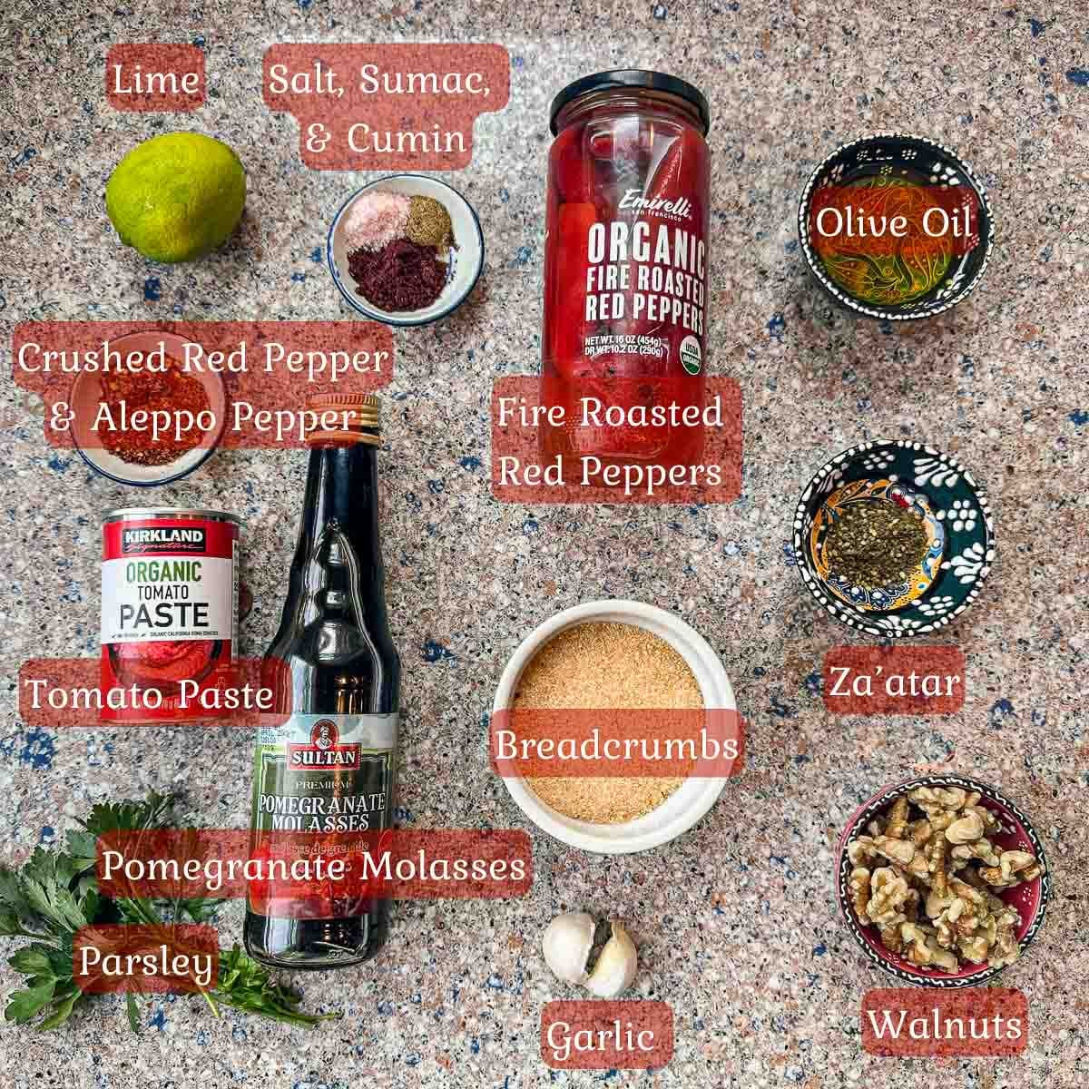 muhammara ingredients including a jar of peppers, spices, bread crumbs, lime, and walnuts.