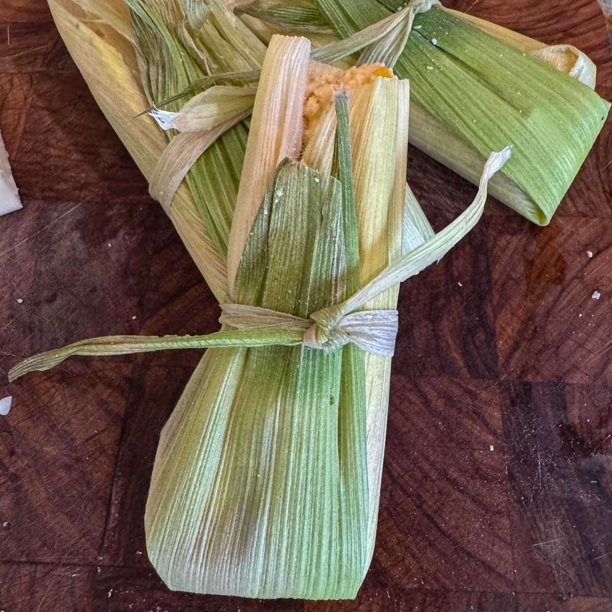tamales de elote on a cutting board