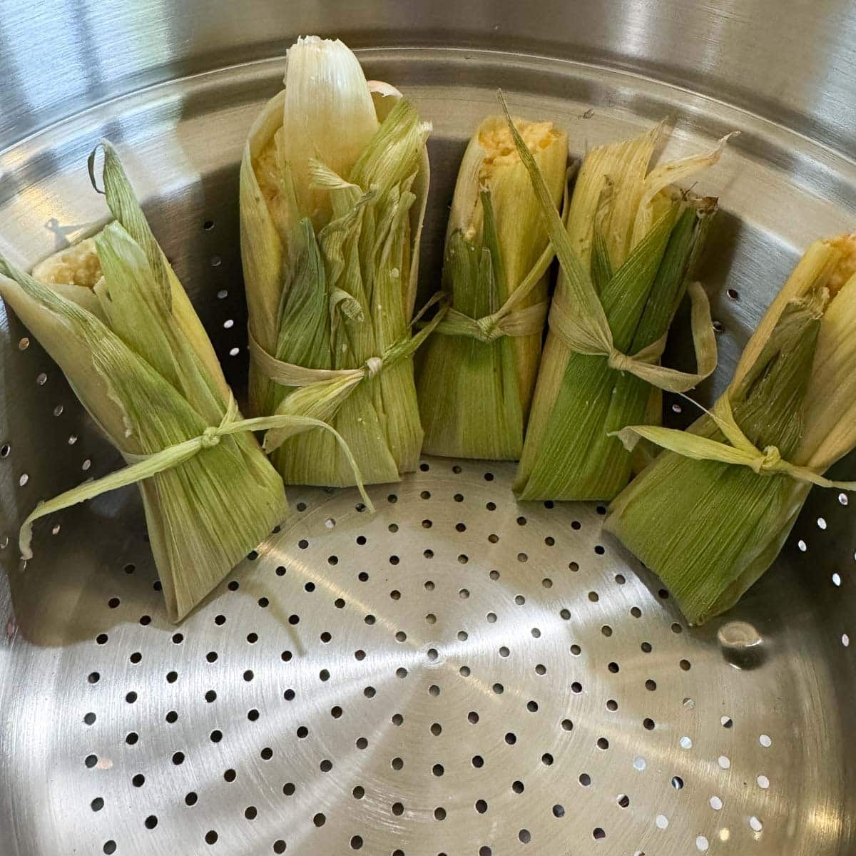 corn tamales in a steamer basket