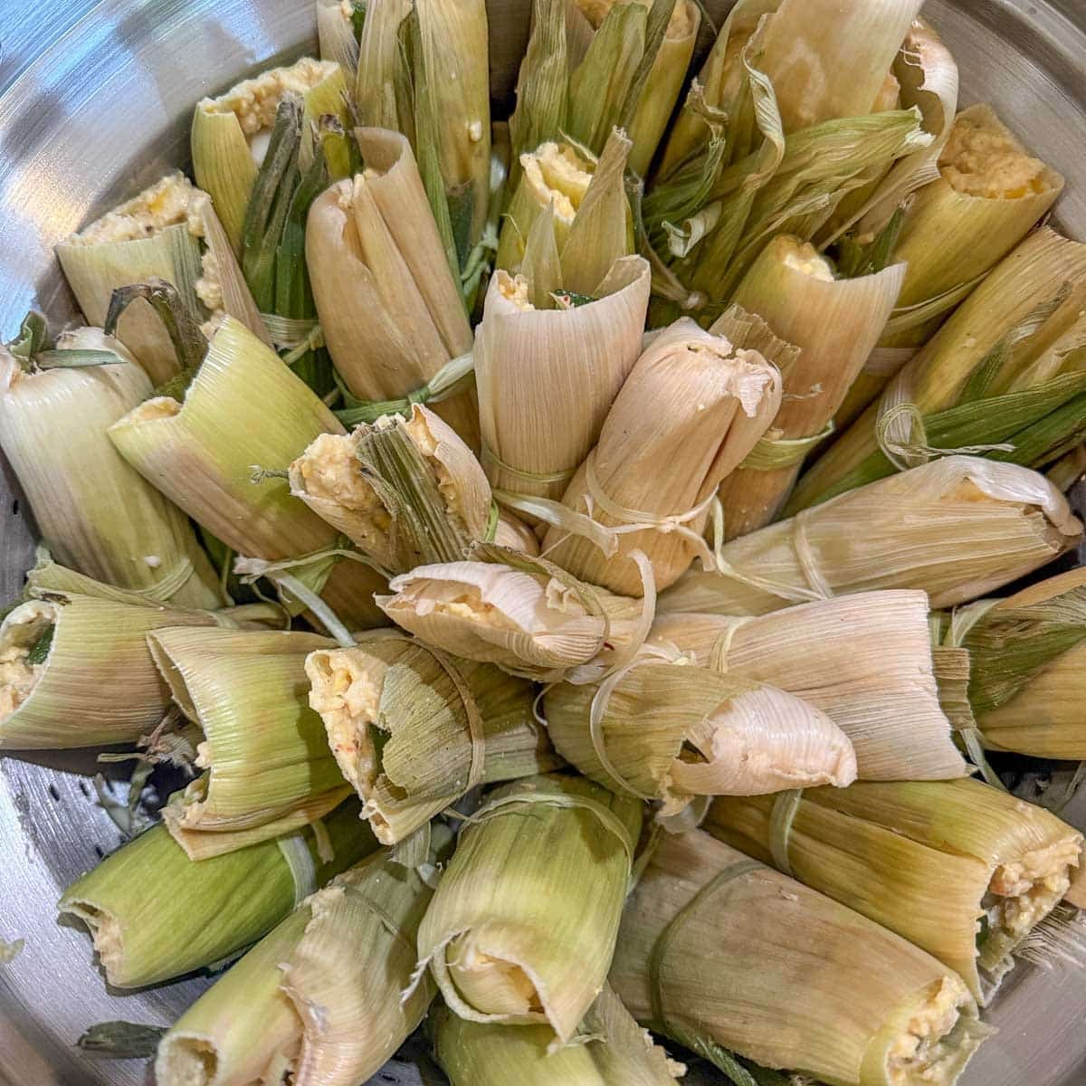 Tamales de Elote in a steamer basket