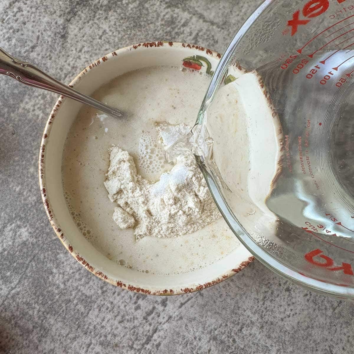 pouring water over masa in a bowl