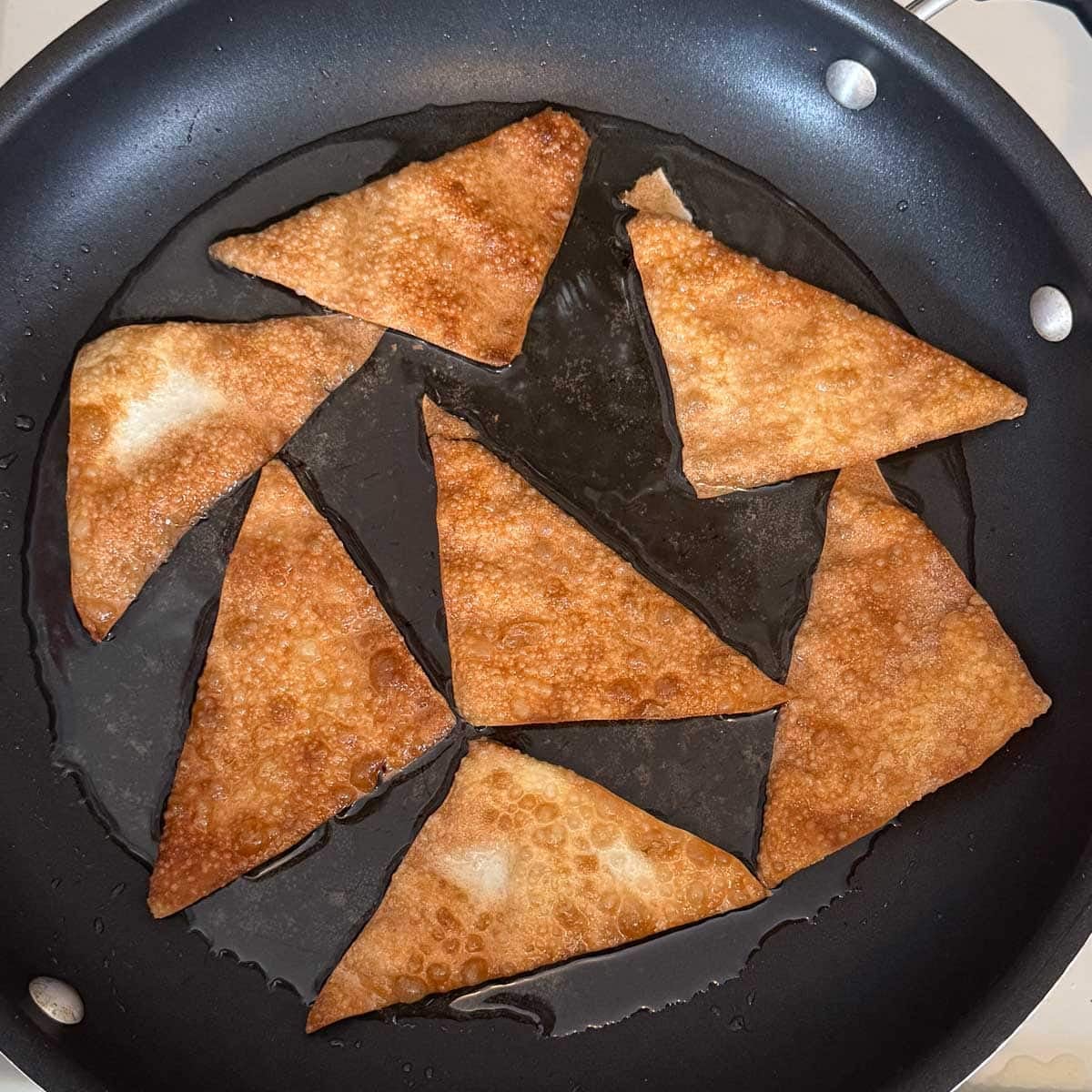 perfectly cooked golden brown wonton chips in oil.