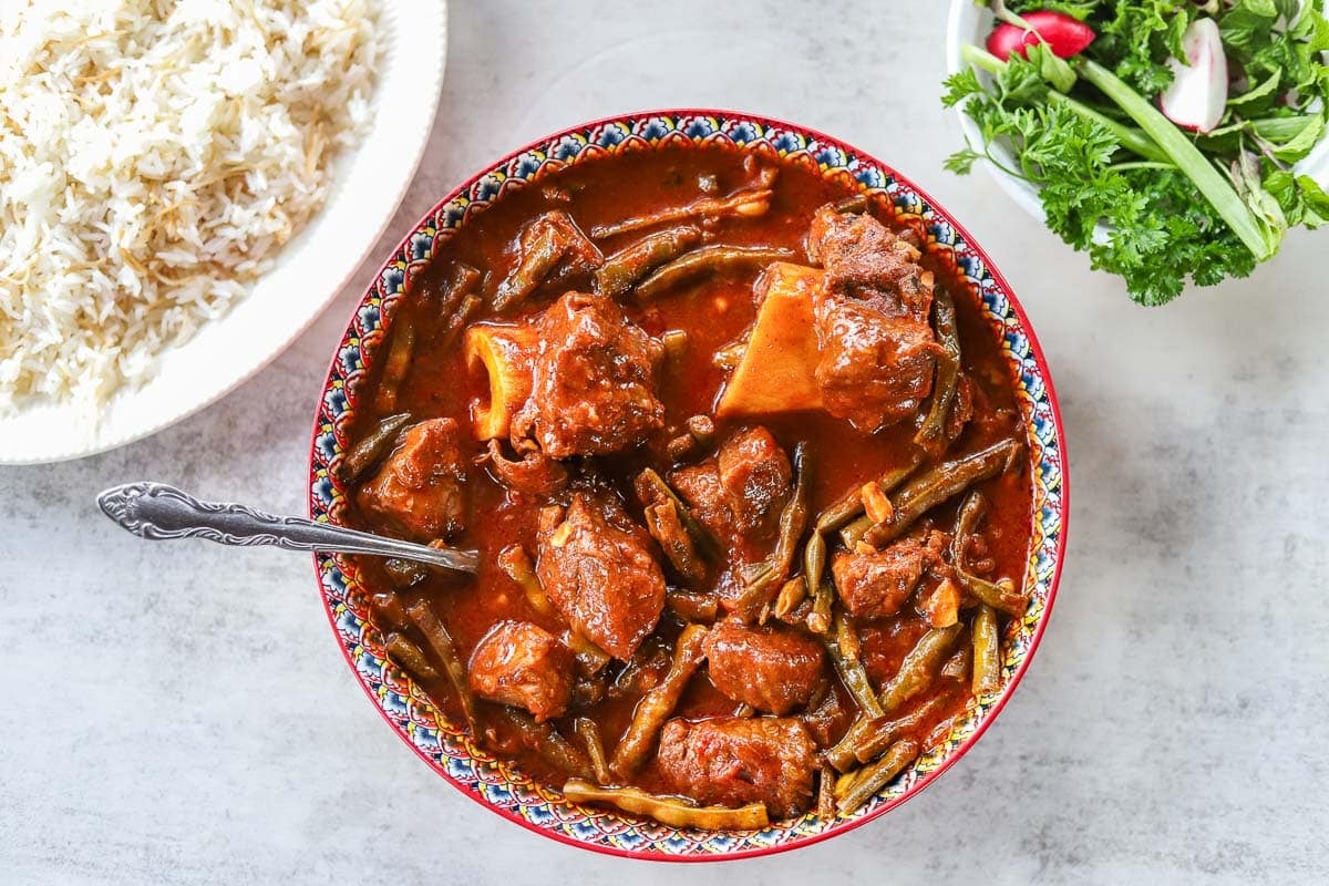 lobia in a bowl with rice and herbs on the side