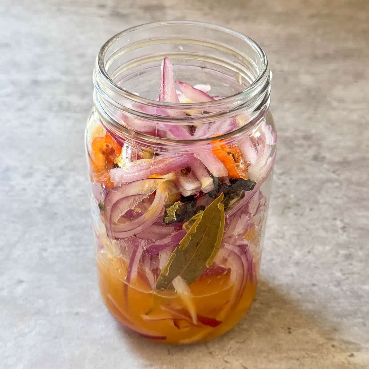 citrus added to onions in jar.