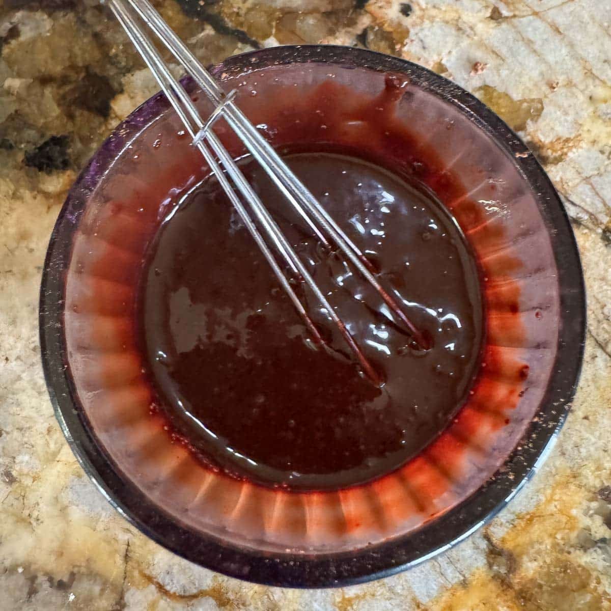 chocolate cherry sauce being whisked in a small bowl