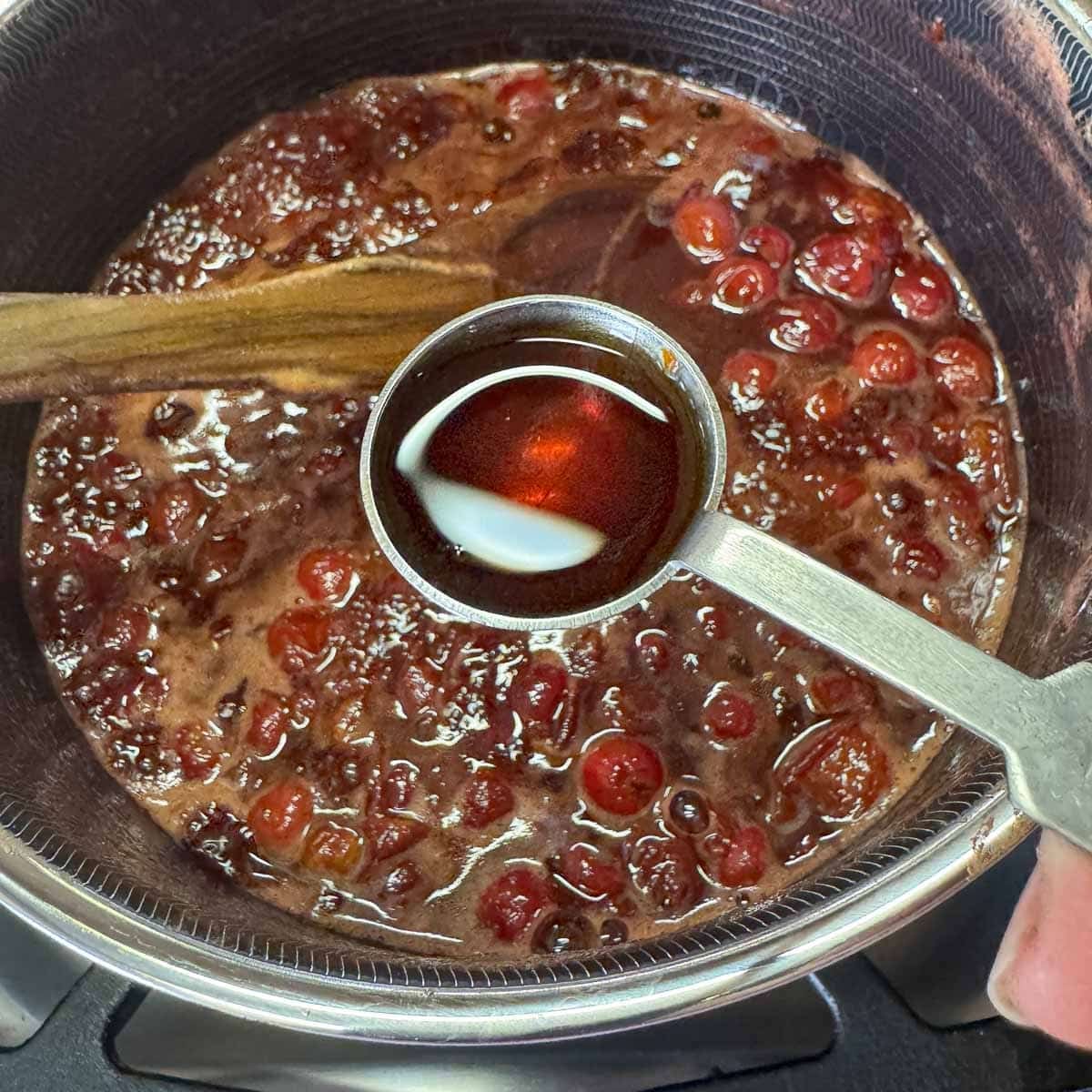 vanilla being added to sour cherry jam