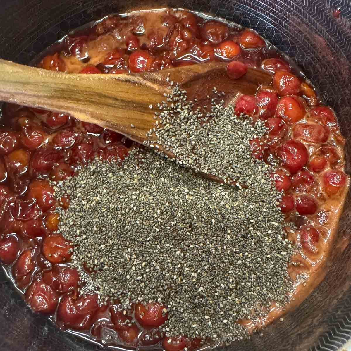 chia seed jam in a pot with a wooden spoon