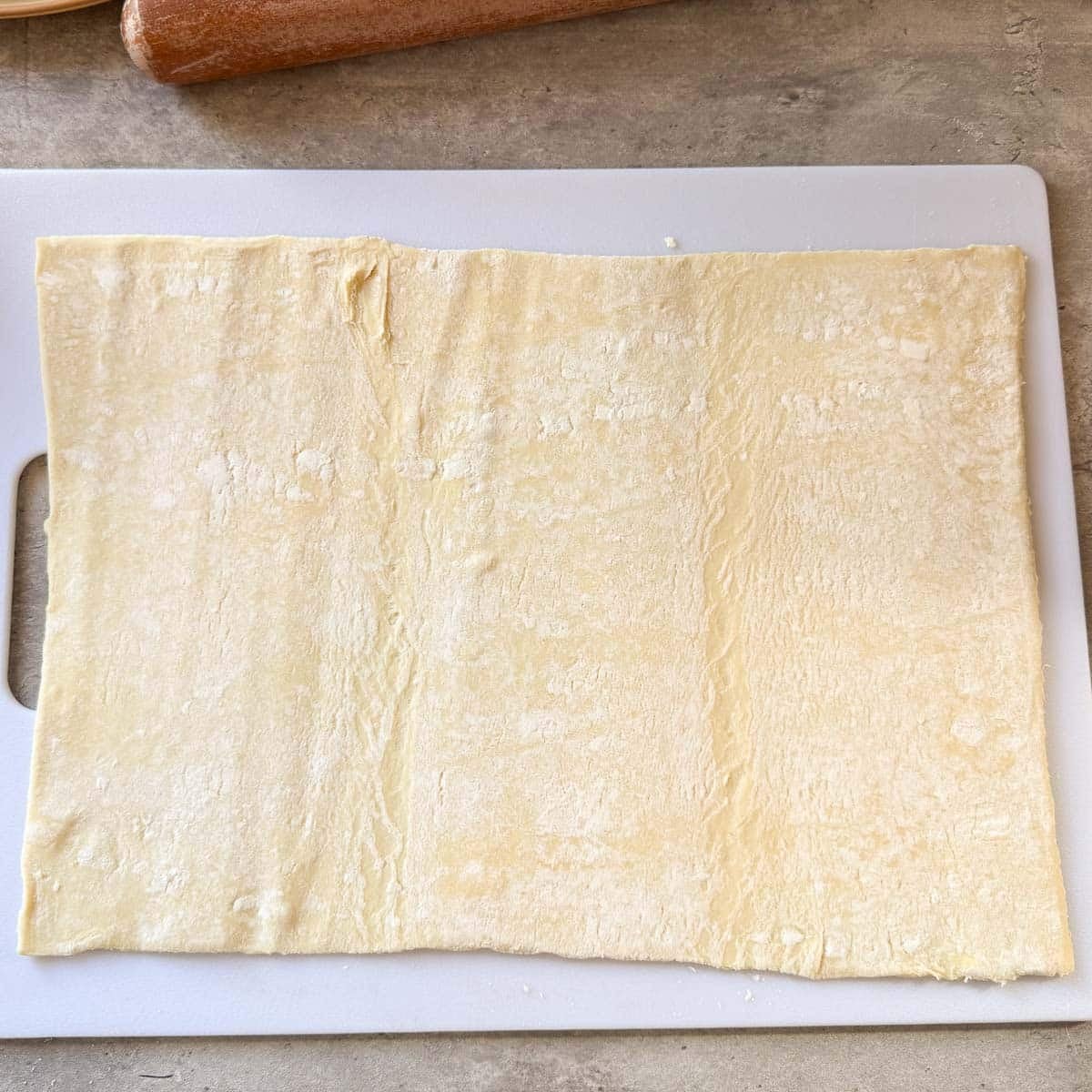 puff pastry rolled out on cutting board.