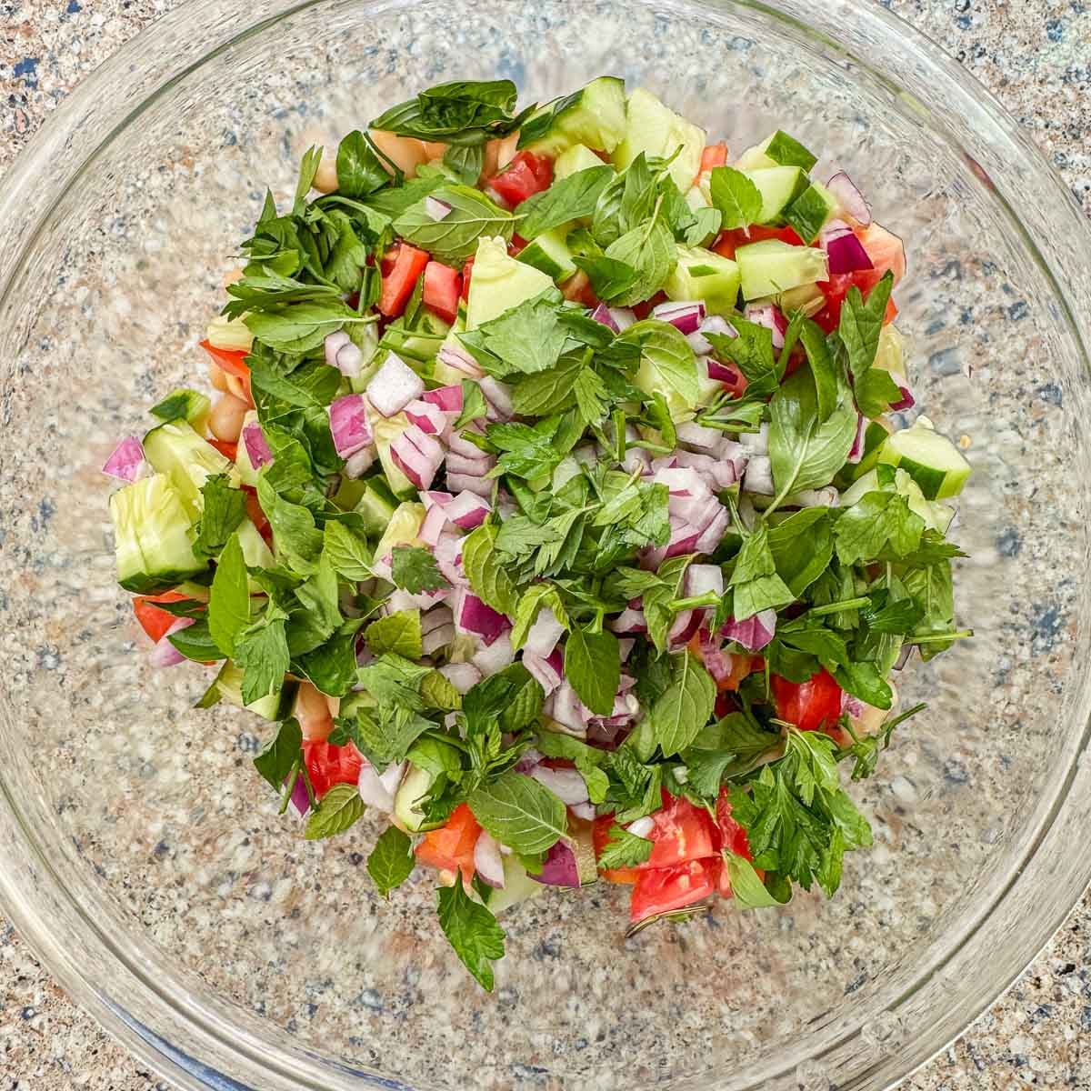 glass bowl with mixed veggies and fresh herbs