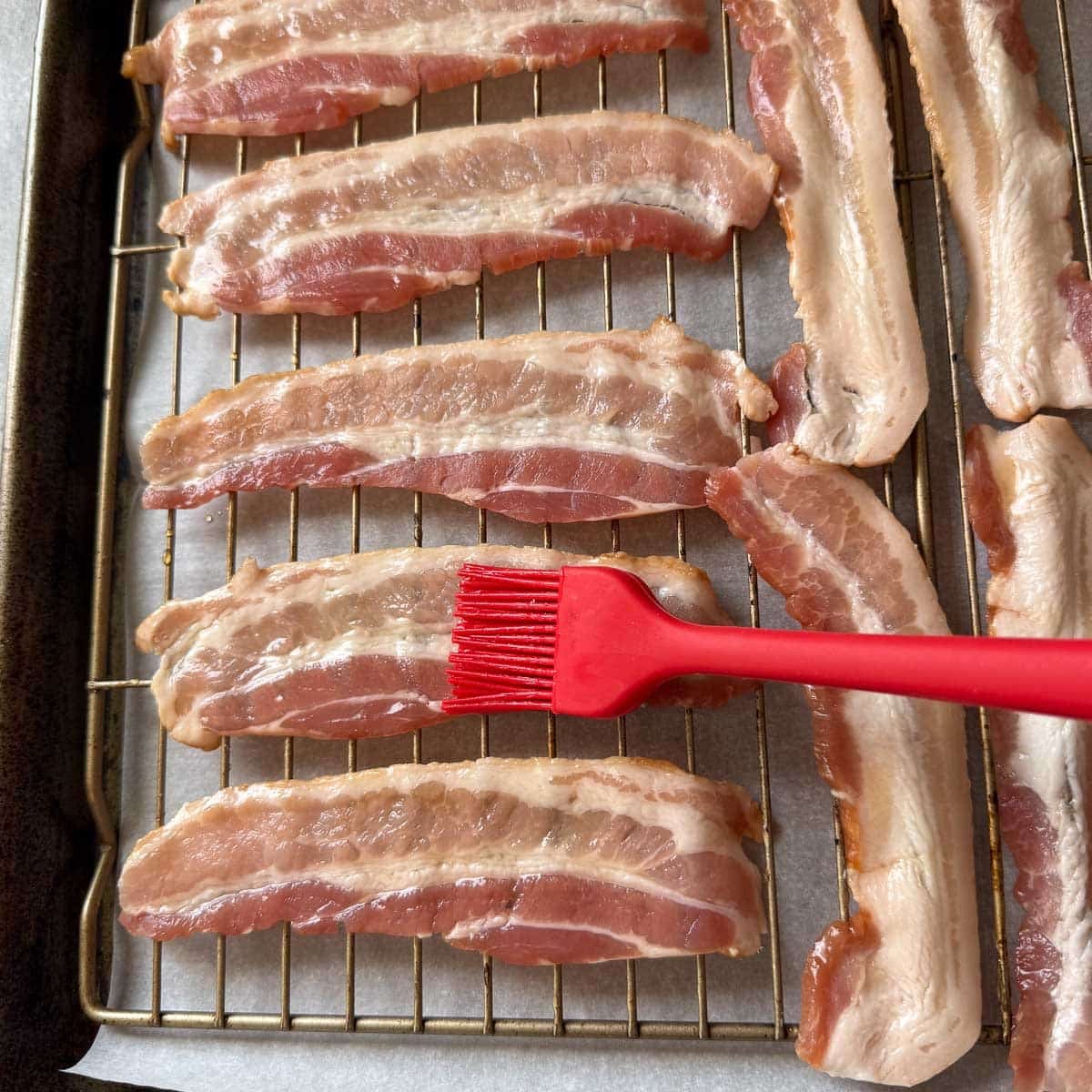 rubber brush spreading hot honey on bacon.
