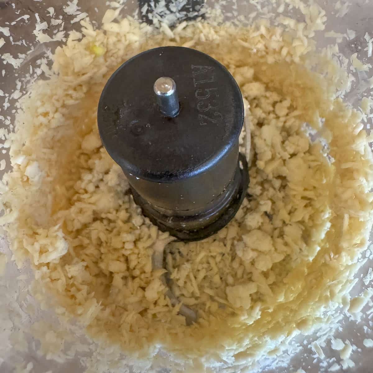 garlic and horseradish being blended in a food processor.