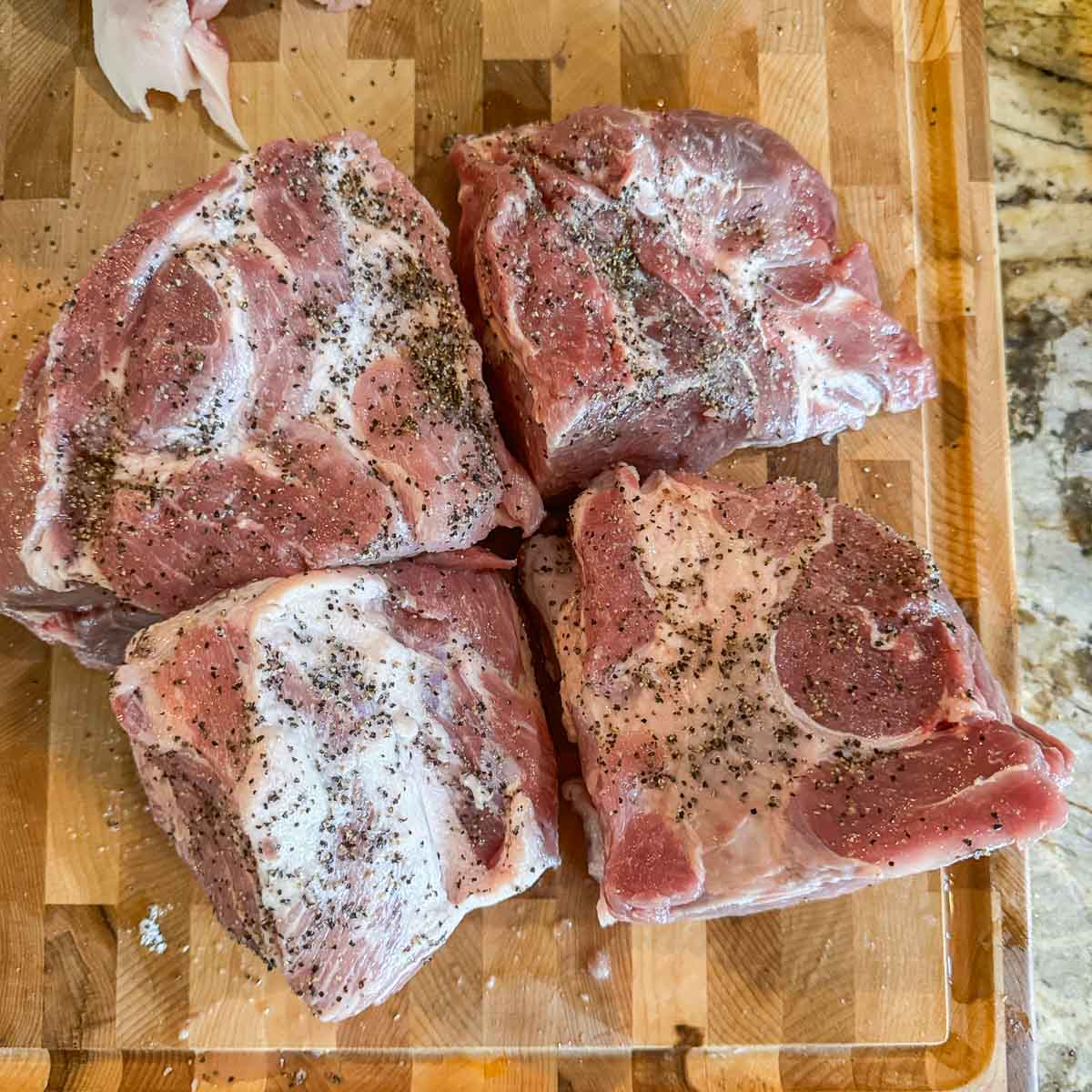 seasoned and quartered pork roast on a cutting board