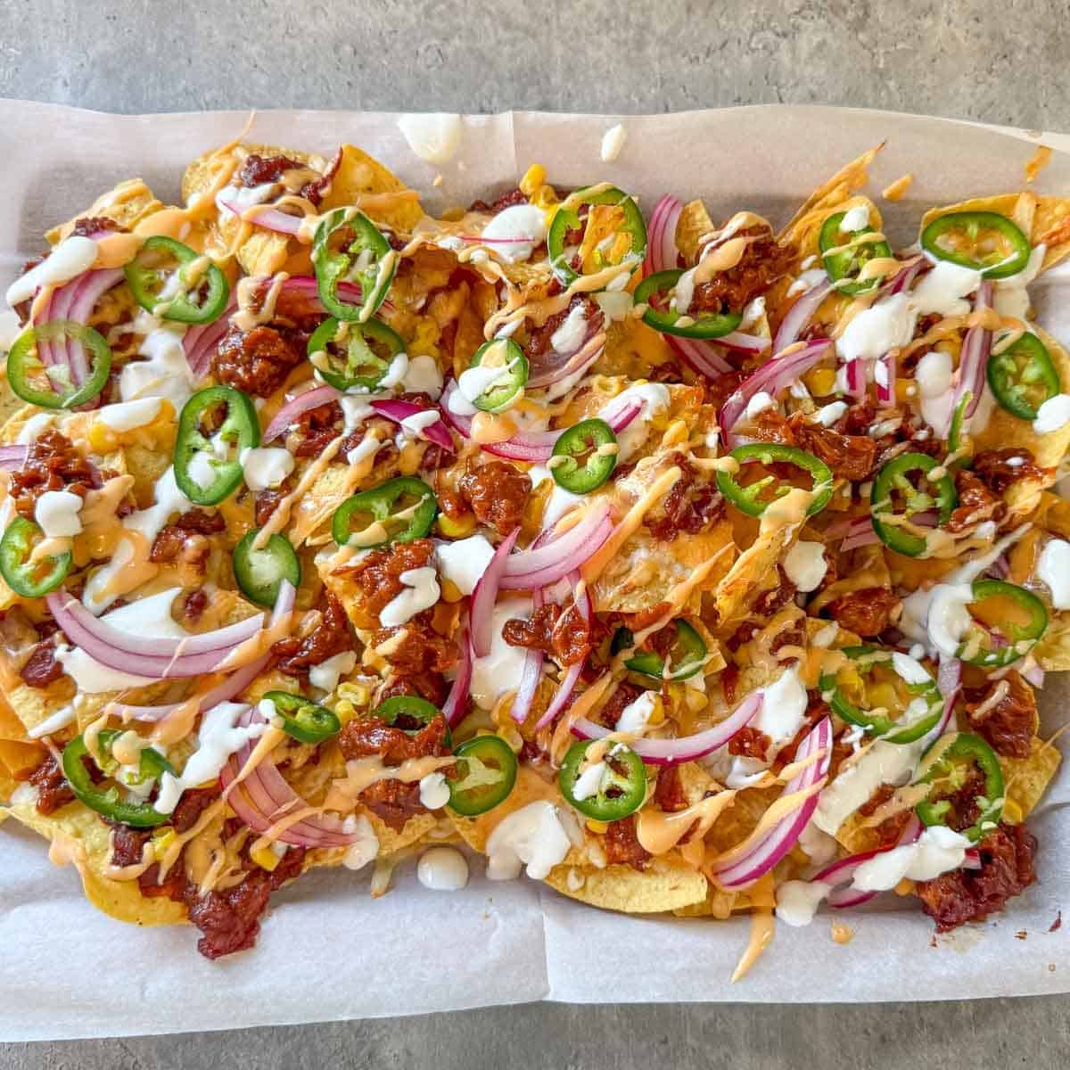 toppings added to pulled pork nachos.