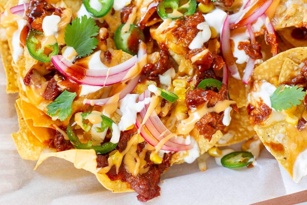 pulled pork nachos topped with pickled onions, cilantro, jalapenos, bbq sauce, etc.