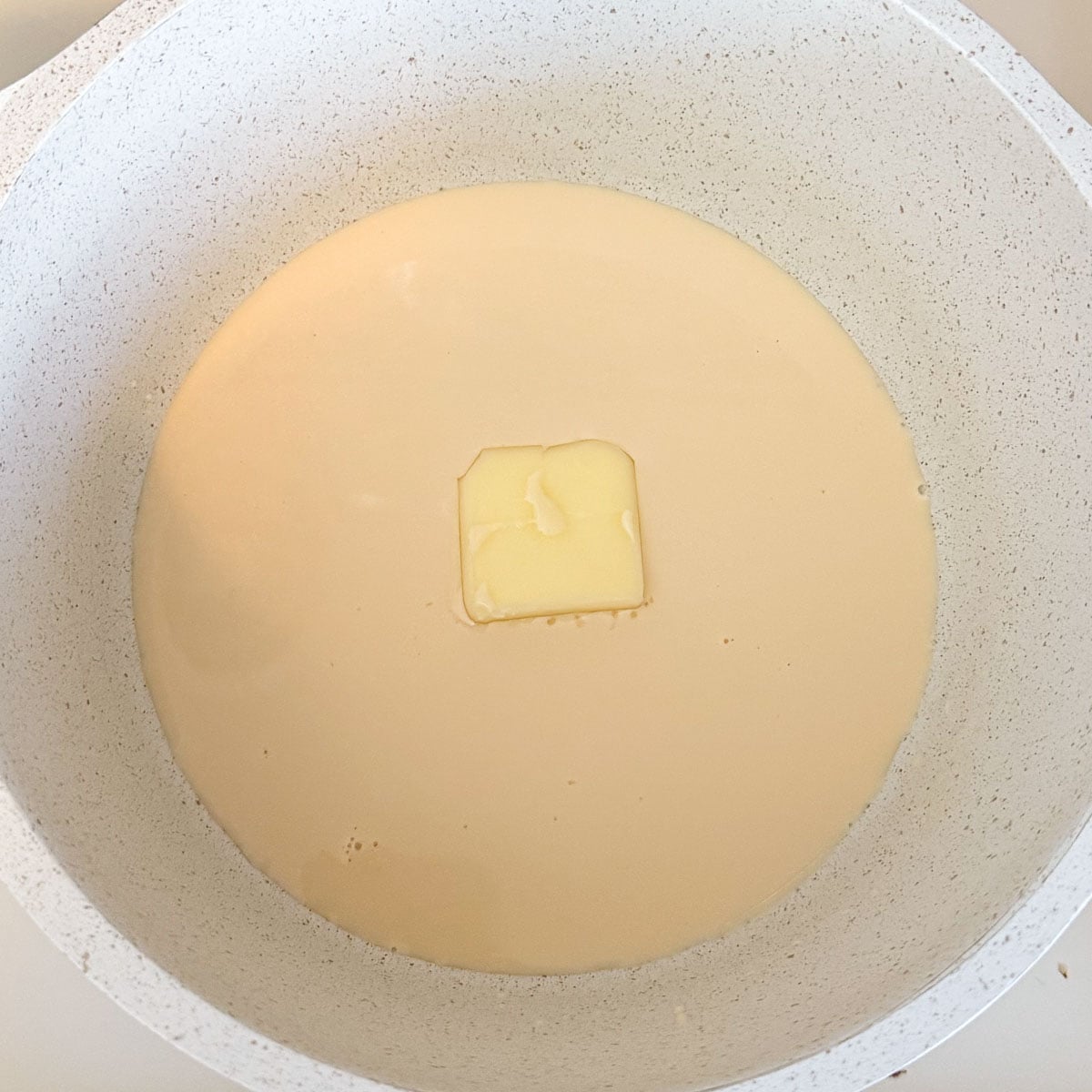 butter and evaporated milk in pot before melting.