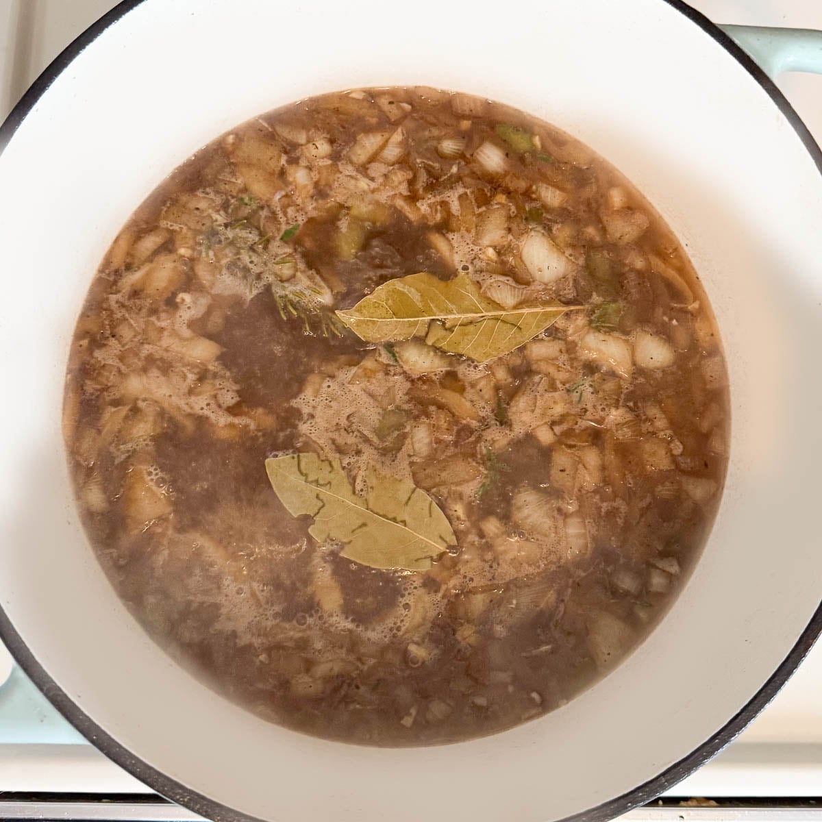 bay leaves and herbs added to the pot.