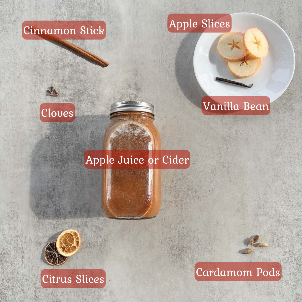 spiced apple cider ingredients including apple juice, spices, citrus and apple slices.