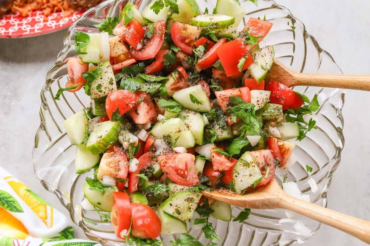 Arabic salad in a bowl with wooden tongs