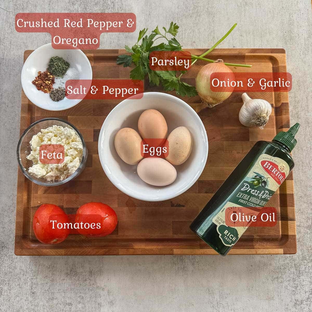 strapatsada ingredients including eggs, feta, spice, tomatoes, onion, and garlic