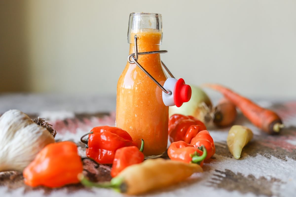 habanero sauce with peppers, carrots, and garlic around it. 