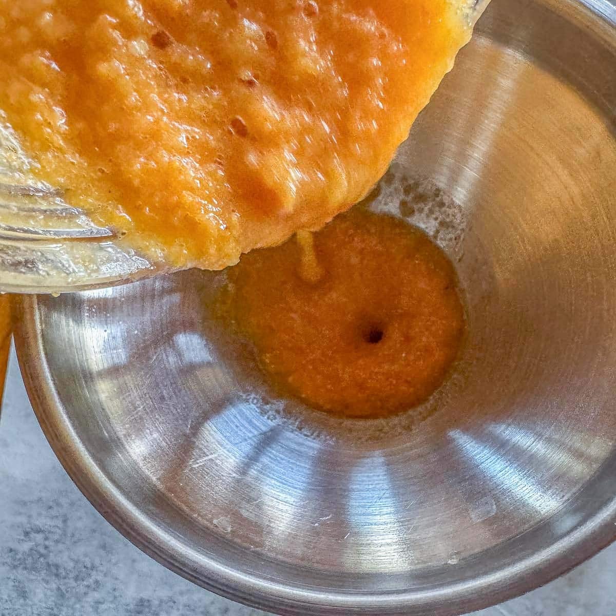 pouring habanero sauce through funnel into jar