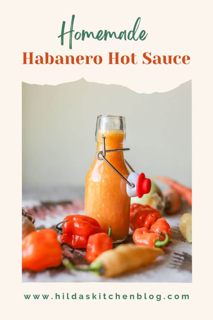 habanero hot sauce in a flip top bottle with peppers and other veggies around it